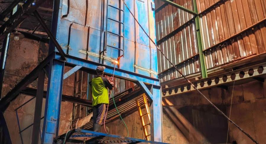 Pembongkaran struktur logam di dalam bangunan pabrik